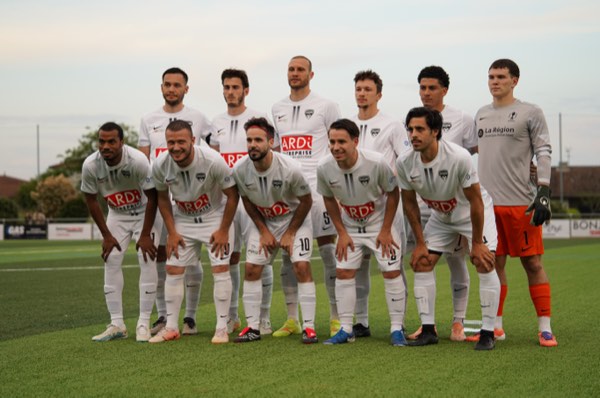 Photo d'équipe en maillot blanc posée sur le terrain avant match