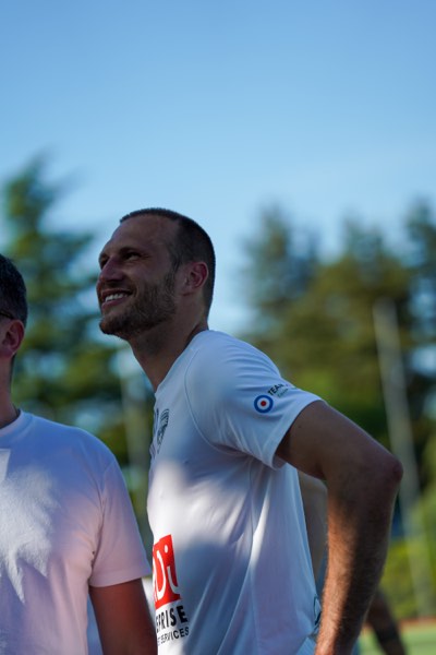 Joueur souriant, ciel bleu et arbres en arrière-plan