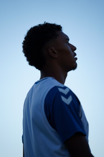 Silhouette de profil d'un joueur en contre-jour sur ciel bleu
